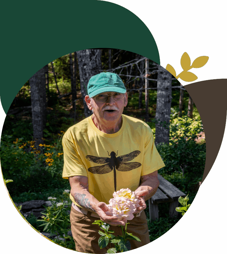 Man holding flowers in a garden setting.